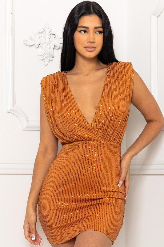 Shimmer in a formal sequin dress that dazzles under the spotlight. The Chloe formal sequin dress features a plunging neckline,   shoulder pads, and a mini-length silhouette. The back features a daring keyhole cutout with single-button closure. The dress is composed of a sequin-adorned lined mesh fabric
