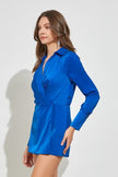 Your next celebration adventure calls for this trendy  blue romper! Party comfortably in this romper featuring long sleeves with cuffs, a collared neckline, wrap front  and short-length skirt look from the front. Side view.