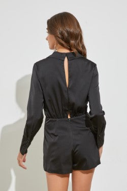 Your next celebration adventure calls for this trendy  black romper! Party comfortably in this romper featuring long sleeves with cuffs, a collared neckline, wrap front  and short-length skirt look from the front.